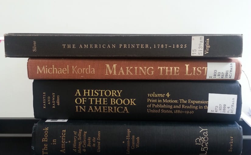 4 books stacked on a desk on the subject of American book publishing and print culture